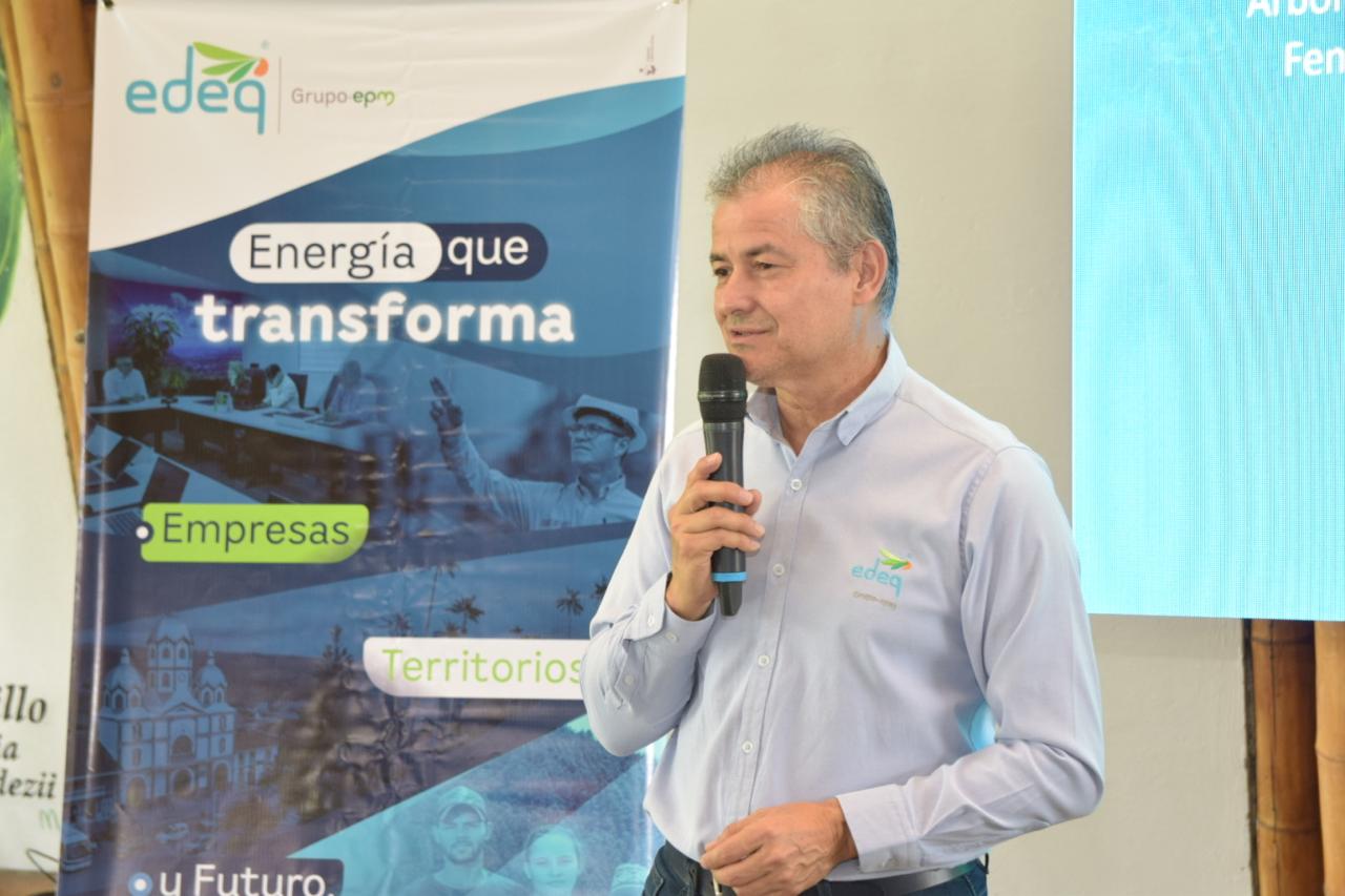 Expositor con micrófono junto a un banner de EDEQ