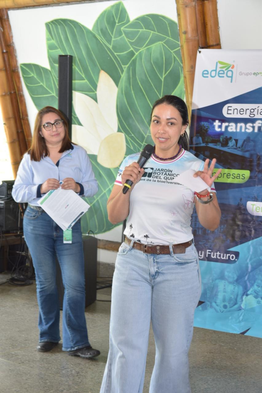 Participante interviene ante los asistentes frente a un banner de EDEQ
